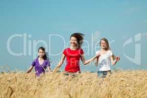 teen girls running at the wheat field