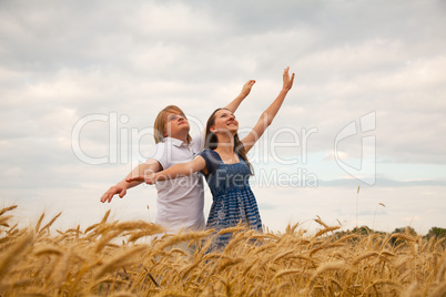 couple staying with raised hands at sunset time