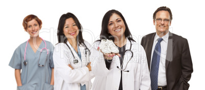 Hispanic Female Doctor or Nurse with Baby Shoes and Support Staf