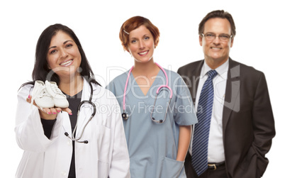Hispanic Female Doctor or Nurse with Baby Shoes and Support Staf