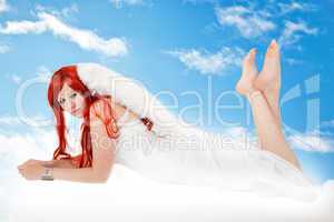 Woman with red hair as an angel in the clouds