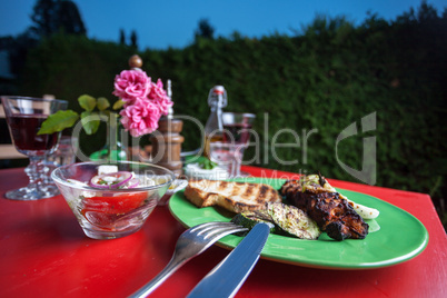 Gegrilltes Hühnerfleisch auf einem grünen Teller im Freien