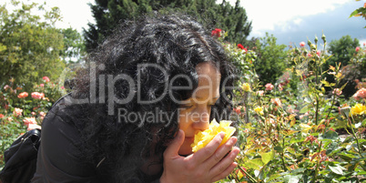 Pretty brunette smelling roses