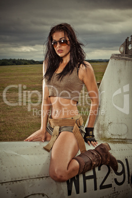 Sexy woman astride aircraft fuselage