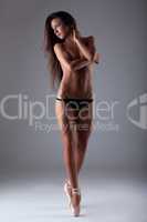 Young beautiful woman posing topless on tiptoe
