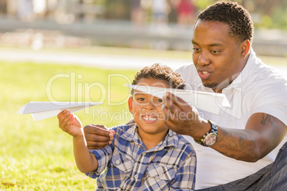 Mixed Race Father and Son Playing with Paper Airplanes