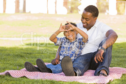 Mixed Race Father and Son Making Heart Hand Sign