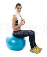 Female fitness trainer sitting on ball