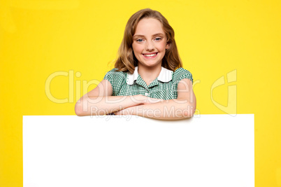 Girl posing behind an advertising board