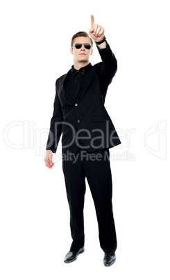 Young handsome man pointing upwards