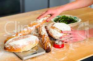 Females hands arranging baguettes and breads