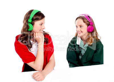 Pretty girls enjoying music. Looking at each other