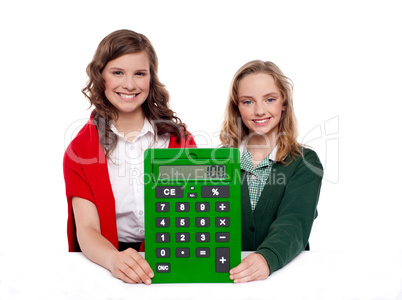 Girls showing big green calculator to camera