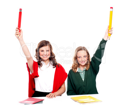 Students showing big pencil in raised arm