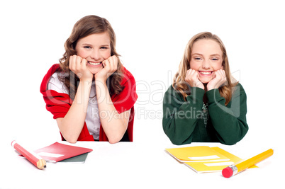 Happy young girls sitting at desk