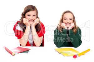 Happy young girls sitting at desk