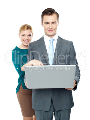 Woman pointing into laptop while guy holding it