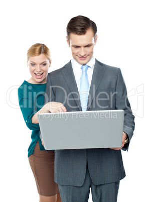 Smiling business people using laptop