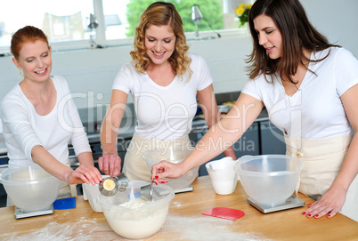 Female chefs team collecting flour from bowl