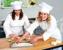 Female chef arranging prepared dough