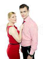 Woman grabbing man from his tie
