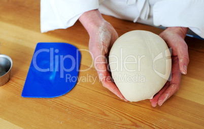 Chefs hand holding a clean finished dough