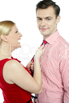 Glamorous woman pulling man by his tie