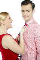 Glamorous woman pulling man by his tie
