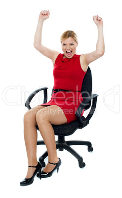 Excited woman sitting in chair. Isolated