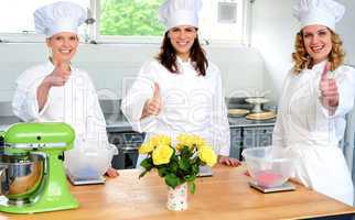 Professional female chefs showing thumbs up