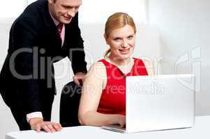 Trendy female boss working with man assisting