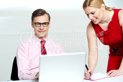 Woman writing information from laptop