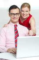 Corporate couple enjoying videos on laptop