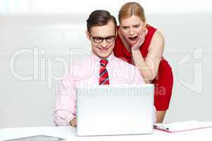 Shocked woman looking into laptop. Man working
