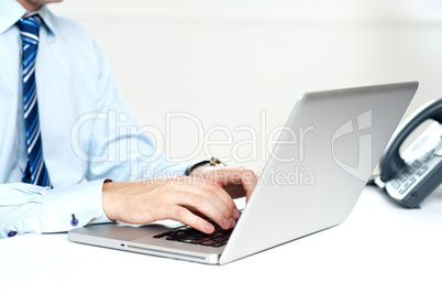 Closeup shot of man working on a laptop