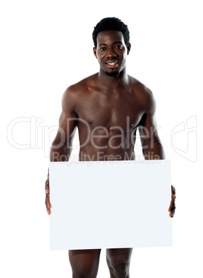 Naked black man holding blank billboard