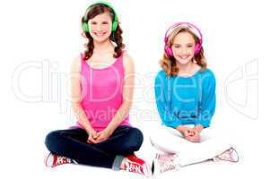 Teenage friends sitting on floor listening music