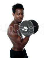 Muscular african guy doing biceps exercise