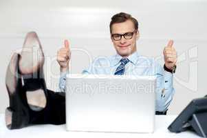 Relaxed businessman gesturing thumbs up