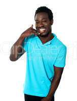 Smiling young man showing calling gesture