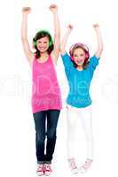Excited young girls enjoying music together