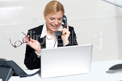 Woman talking on phone holding eye glasses