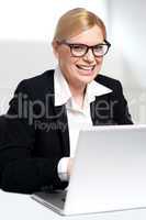 Smiling young female executive at work desk