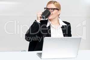 Businesswoman enjoying coffee at work desk