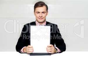 Corporate man showing blank clipboard