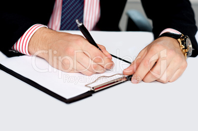 Male's hand writing on blank notepad