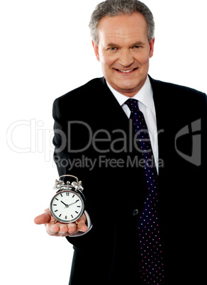 Corporate man showing alarm clock