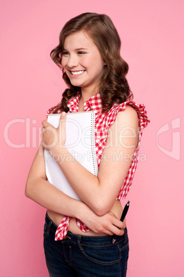 Trendy young girl posing with spiral notepad