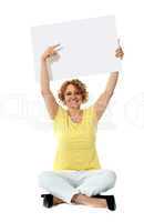 Senior woman pointing at blank ad board