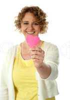 Woman showing pink paper hear to camera